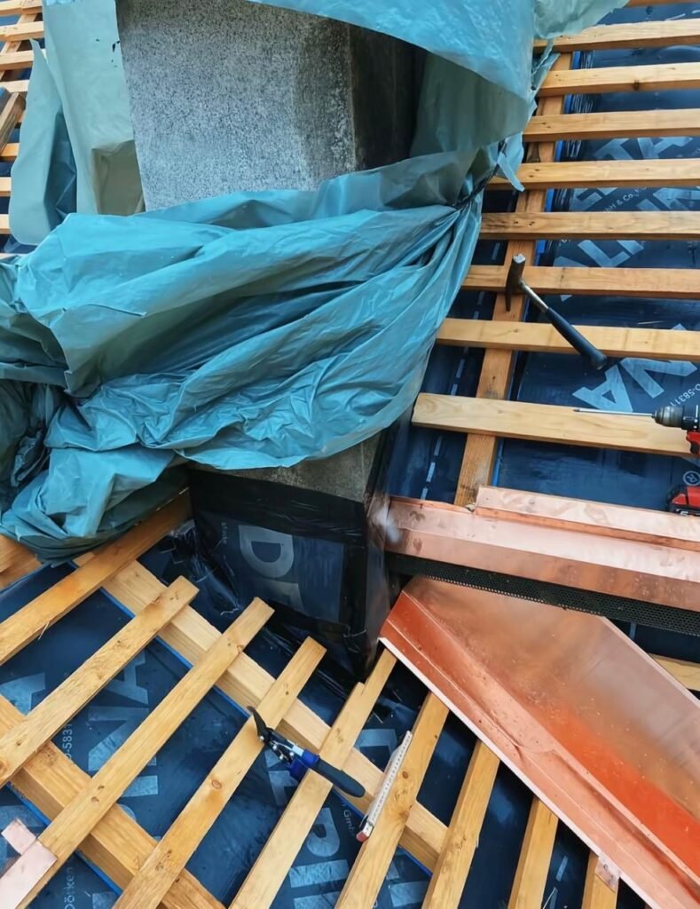 Abergement de cheminée en cuivre posé sur liteaunage neuf et écran sous toiture