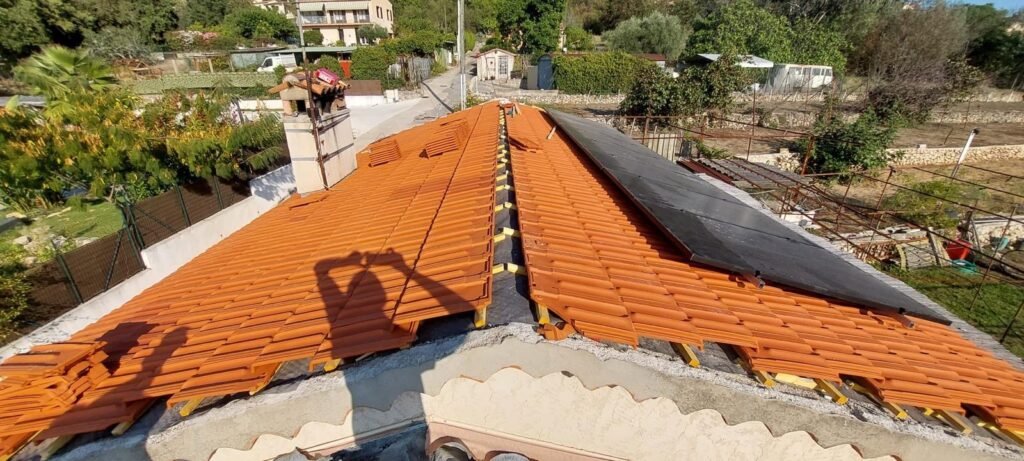 Couvreur rénovant une toiture en tuiles avec intégration de panneaux solaires